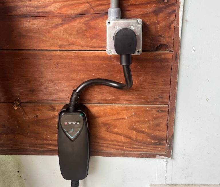 A Level 2 EV charger installed on a garage wall by All Covered Electric